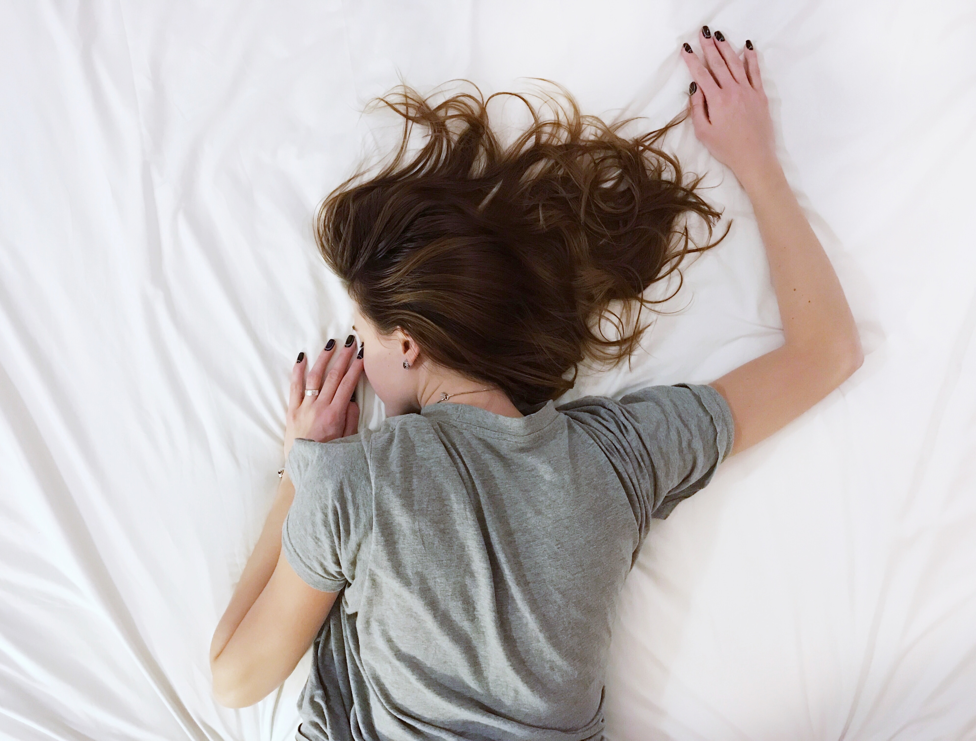 Window blinds Glasgow help woman lying on bed to sleep. 